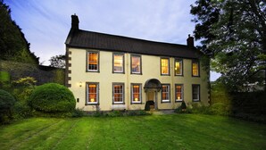A two-story building with a symmetrical facade, multiple windows, and a central entrance. - Beautiful 5bedroom house sleeps13 hottub (Shepton Mallet)
