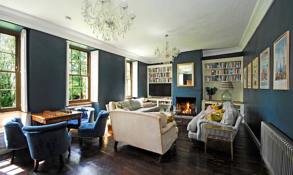 A living room with a fireplace, bookshelves, and a chessboard.