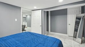 A bedroom with a bed, a wardrobe, and a mirror.