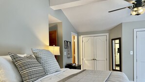 A bedroom with a bed, a nightstand, a lamp, a wardrobe, and a ceiling fan. - Beautiful Farmhouse Style Country Home with Indoor Pool! (New Richmond)