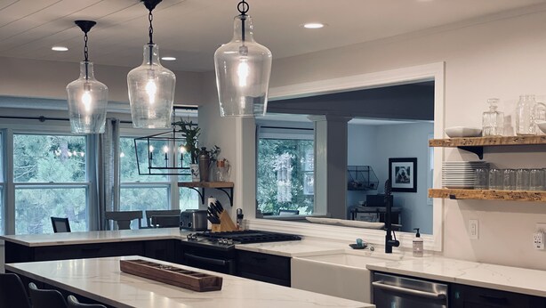 A modern kitchen with a central island, stainless steel appliances, and pendant lighting. - Beautiful Farmhouse Style Country Home with Indoor Pool! (New Richmond)