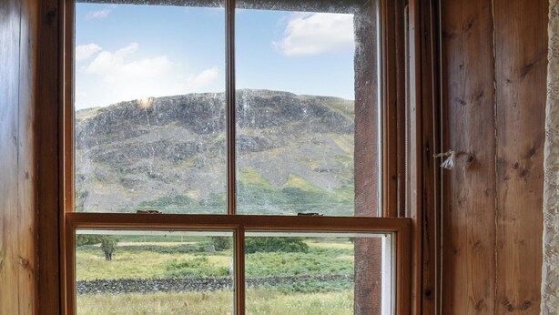 A window with a view of a grassy field and a hill. - 3 bedroom accommodation in Howtown on Ullswater (Howtown on Ullswater)