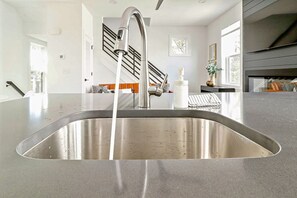 A modern kitchen with a stainless steel sink, a faucet, and a countertop. - 26th and Pacific with Ocean Views! (Virginia Beach)