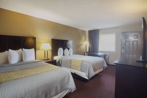 A hotel room with two beds, a desk, a TV, and a window. - Deerfield Inn By Capital O Blytheville AR I55 (Blytheville)