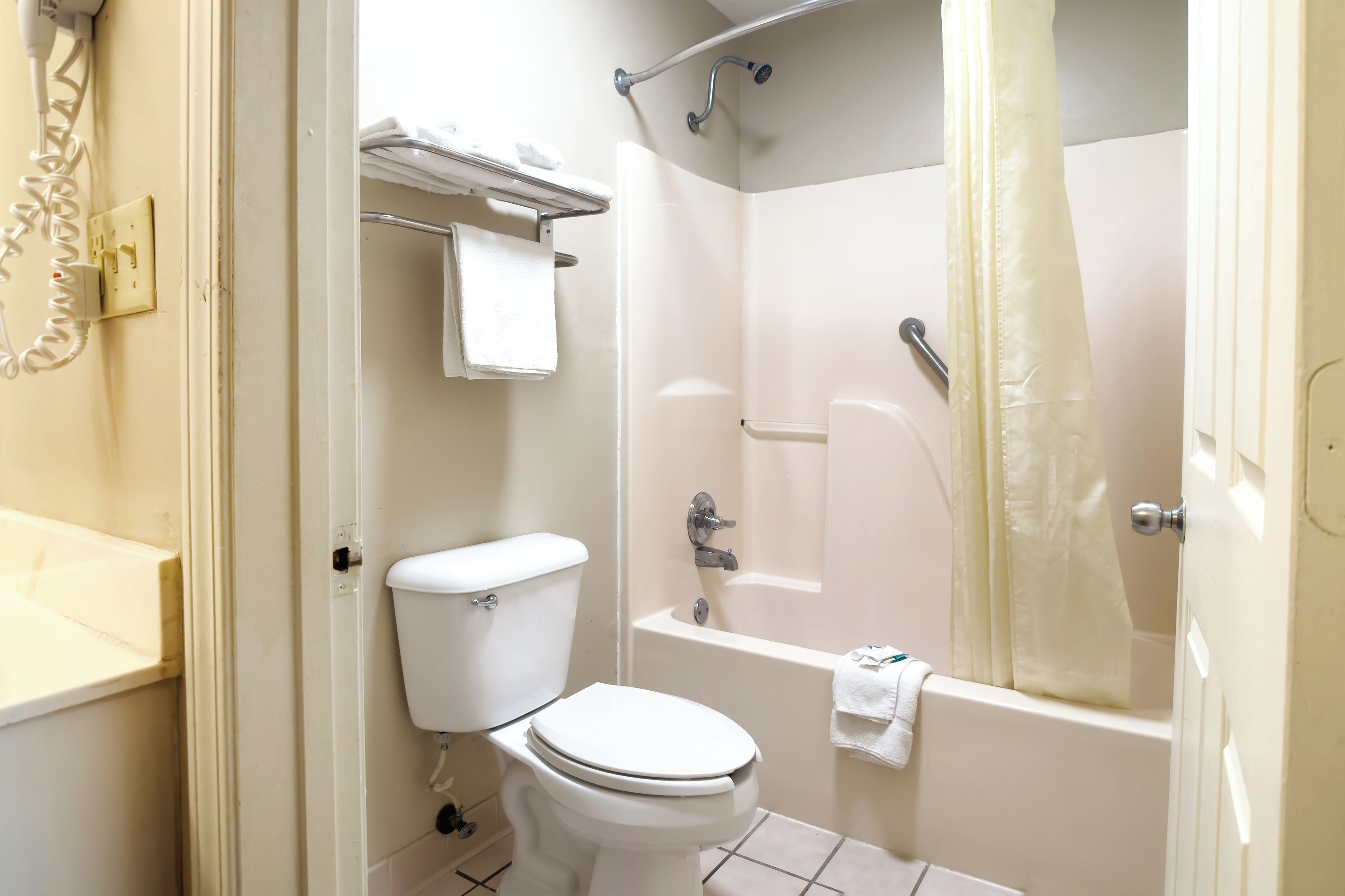 Une salle de bain équipée de toilettes, d’une baignoire et d’un rideau de douche.
