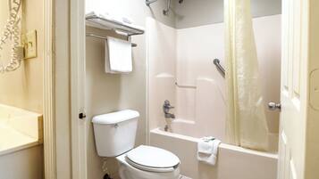 Une salle de bain équipée de toilettes, d’une baignoire et d’un rideau de douche.