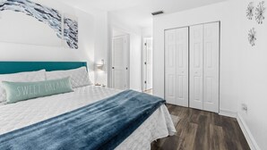 A bedroom with a bed, a teal headboard, a blue blanket, and a pillow with the text "SWEET DREAMS".
