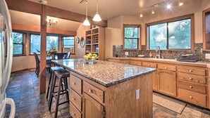 A spacious kitchen with granite countertops, wooden cabinets, and a large island. - Deck + Grill: Mtn Haven in Stanislaus Nat'l Forest (Arnold)