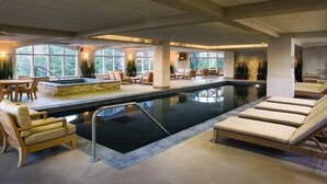 An indoor swimming pool with lounge chairs and a sun terrace.