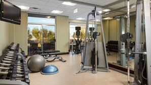 A gym with exercise equipment, a television, and a large window. - 1 Bedroom | FREE Breakfast + Pool Access & Hot Tub (Las Vegas)
