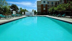 A clear blue pool with lounge chairs and a warning sign. - Equipped Suite Near the Airport! Fitness Center + Free Breakfast (Plainfield)