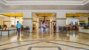 A spacious lobby with a central chandelier, seating areas, and a reception desk. - Condominio 02 recamaras Enna Inn Ixtapa (Ixtapa)