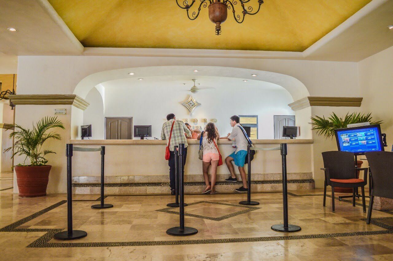 A reception area with a counter, a chandelier, and a digital screen.