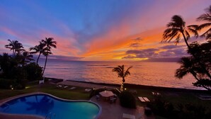 A pool area with a view of the ocean at sunset. - Aloha Maui Condos (Lahaina)