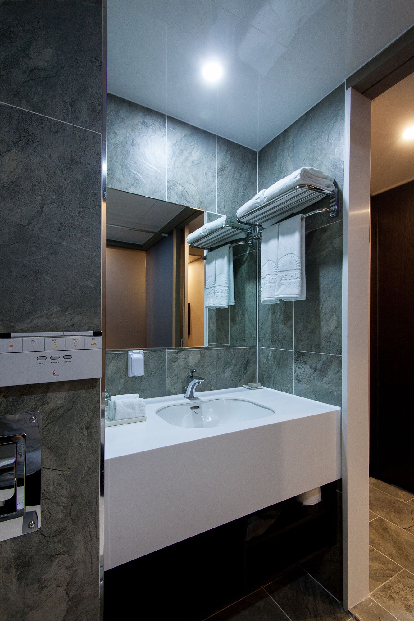 Un baño moderno con tocador doble lavamanos, un espejo grande y un perchero para toallas.