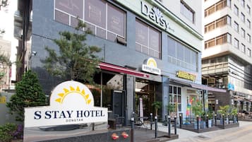 The exterior of S Stay Hotel with a sign for Burger & Fries.