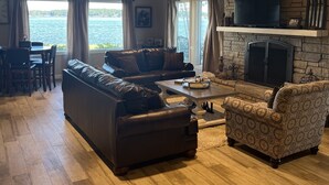 Una sala de estar acogedora con chimenea de piedra, sofás de cuero y un televisor.