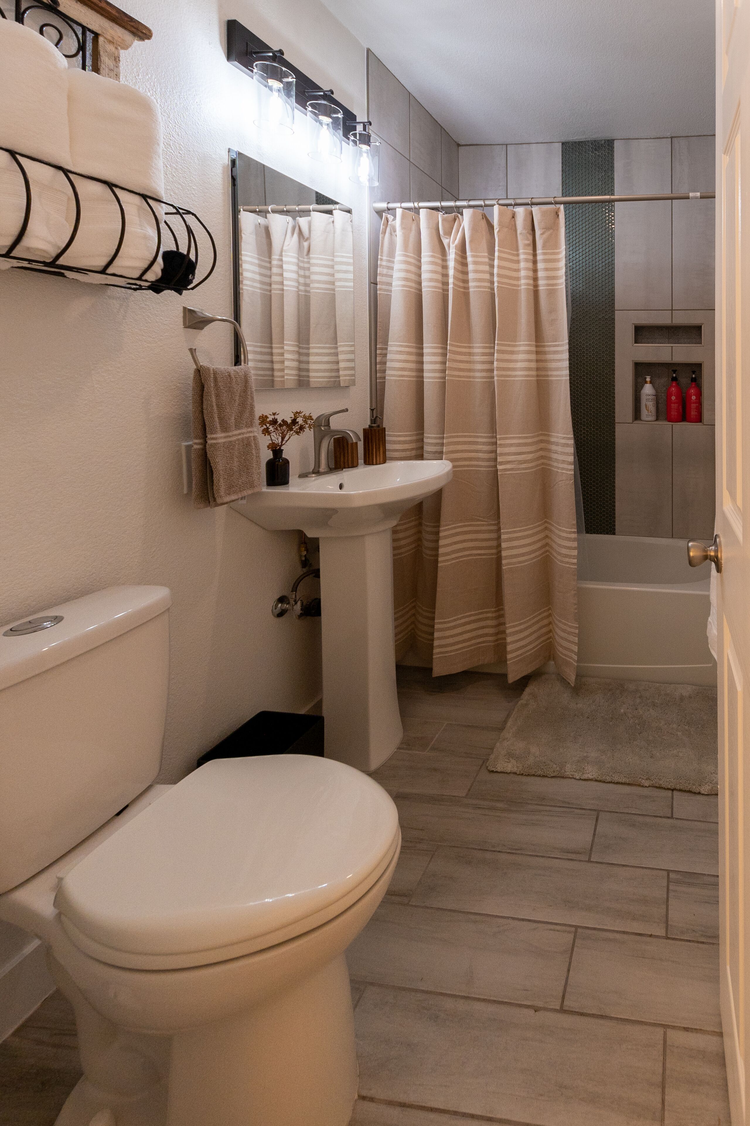 A bathroom with a toilet, sink, and shower curtain.