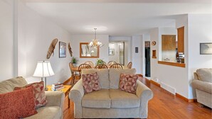 A living room with a sofa, a coffee table, and a dining area with chairs and a table.