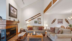 A living room with a fireplace, two sofas, a coffee table, and a rug.