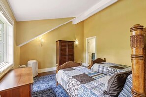 Ein Schlafzimmer mit zwei Betten, einem Holzschrank, einem Heizkörper und einem Fenster.