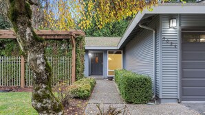 A residential house with a garage, a covered porch, and a well-maintained garden.