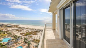 A balcony with a view of the beach and ocean.