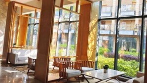 Un interior moderno con ventanas amplias, un comedor con muebles de madera y vistas a espacios verdes.