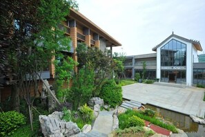 Un edificio de estilo arquitectónico moderno, un camino de piedra y un pequeño elemento de agua.
