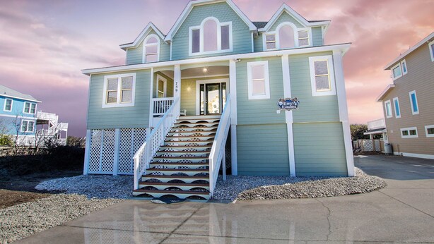 A two-story house with a porch and a staircase leading to the entrance. - OCEANFRONT, Private Pool, Pool Table, Ocean Views, BU70, Kings Landing (Corolla)