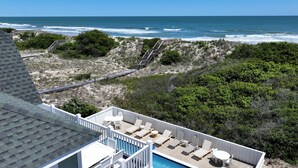A rooftop pool area with a view of the ocean, a wooden deck, and a staircase leading to the beach. - OCEANFRONT, Private Pool, Pool Table, Ocean Views, BU70, Kings Landing (Corolla)
