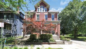 A two-story brick house with a gabled roof and a front porch.