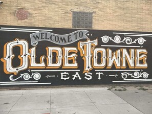 Ein Wandgemälde an einer Ziegelwand mit dem Schriftzug "WELCOME TO OLD ETONE EAST" in stilisierter Schrift.