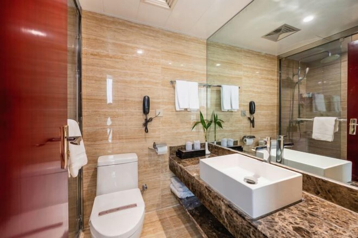 Un baño moderno con una bañera grande, cabina de ducha de vidrio y encimera de mármol.