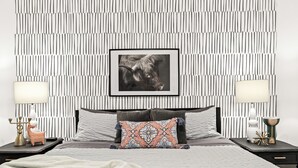 A modern bedroom with a striped wall pattern, a framed picture, two bedside tables with lamps, and a decorative deer figurine. - Cozy Modern 1BR Close to Downtown (Mount Clemens)