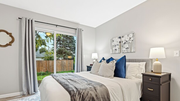 A bedroom with a bed, nightstands, a lamp, and artwork on the wall. - Quiet Cozy End Unit Near Mt. Clemens Downtown (Mount Clemens)