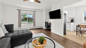 Een moderne woonkamer met een bank, een salontafel en een televisie.