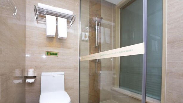 A modern bathroom with a glass-enclosed shower, a toilet, and a towel rack. - Vienna International Hotel Nanning Wuyi Fude (Nanning)