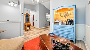 Un salon moderne avec un coin bar, des meubles en bois et une moquette rouge.