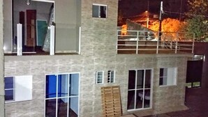 Un edificio a due piani con una piscina sul retro.