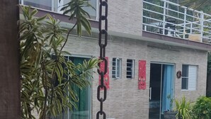 Una casa con piscina, piante in vaso e una catena appesa al soffitto.