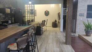 Una cucina con un piano di lavoro in legno, un frigorifero e un forno a microonde. C'è un'area pranzo con sedie e un tavolo. Un ghirlanda natalizia è appesa al muro.