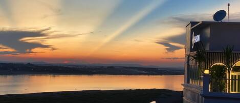A hotel with a view of a sunset over a body of water.