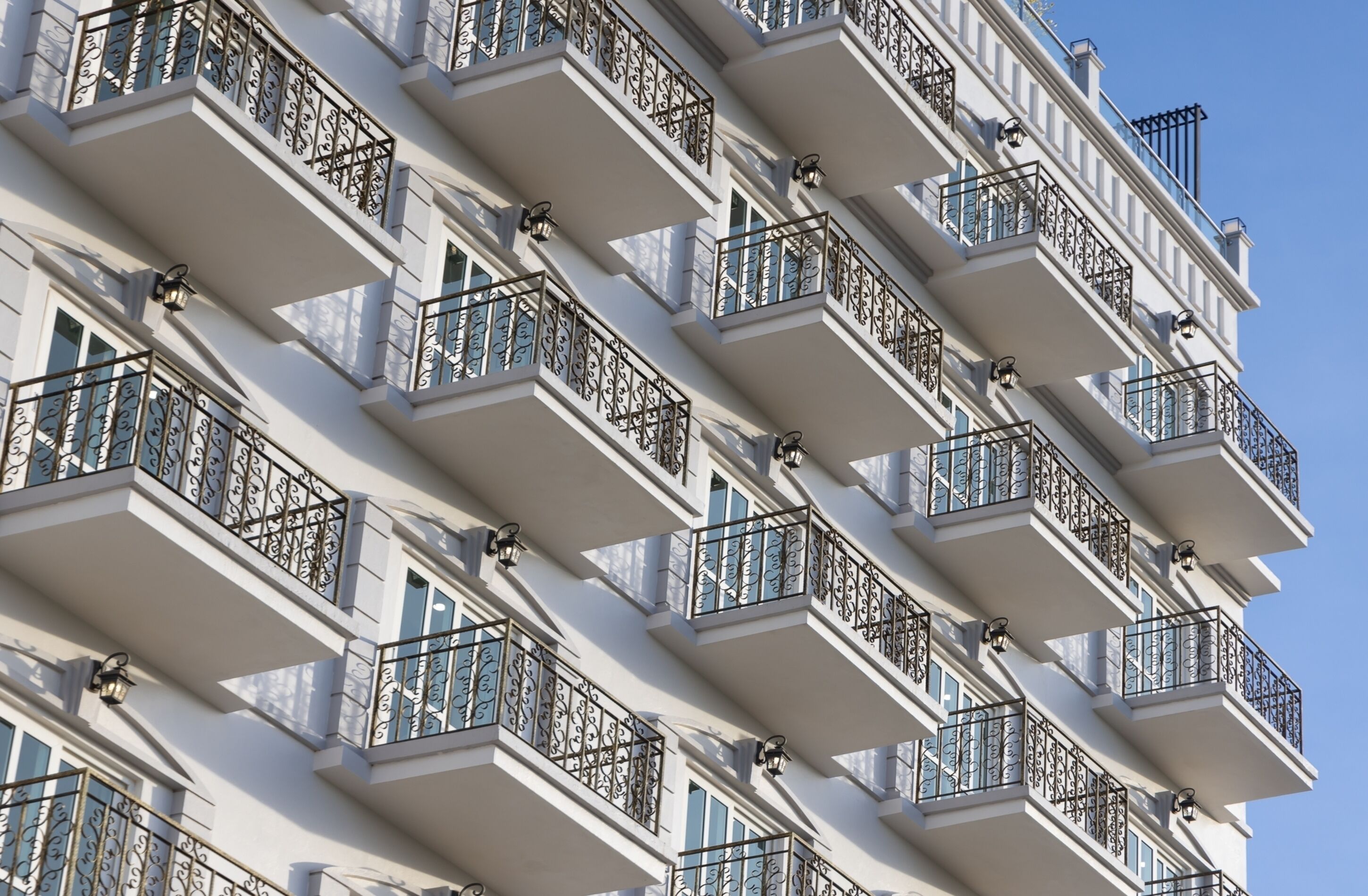A multi-story building with balconies featuring wrought iron railings and windows.