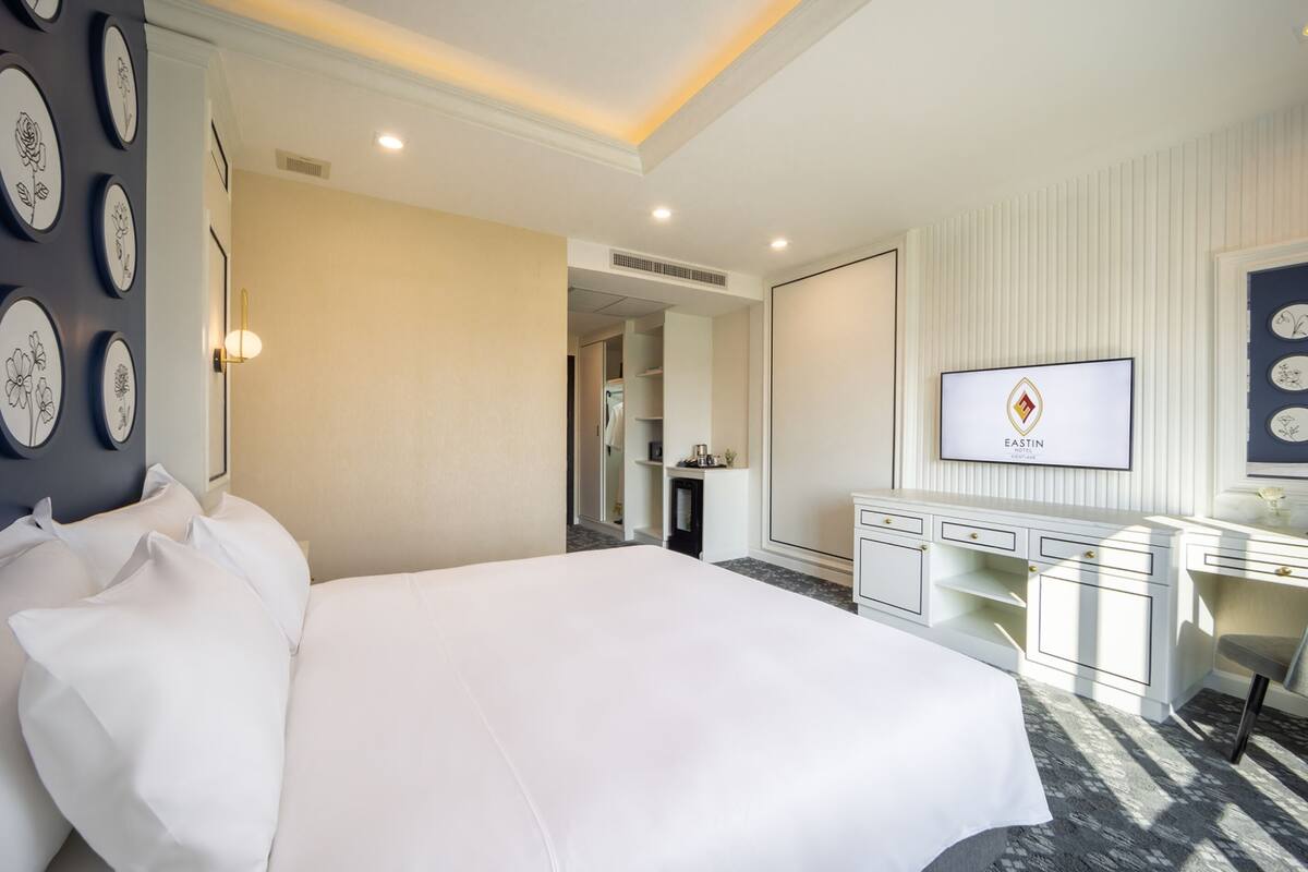 Une chambre d’hôtel avec un grand lit, un bureau et une télévision.