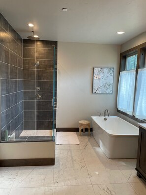 A modern bathroom with a glass-enclosed shower, a freestanding bathtub, and a small stool. - Mountain Escape 5BR/5.5BA sleeps 10 w/hot tub on golf course in Suncadia.  (Cle Elum)