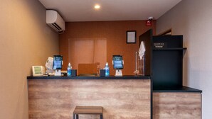 A reception desk with a wooden finish, a small stool, and a digital welcome screen. - HOTEL R9 The Yard Buzen (Buzen)
