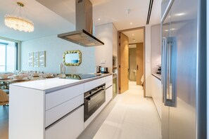 A modern kitchen with a central island, stainless steel appliances, and a chandelier.