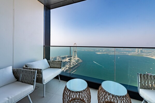 A balcony with a view of a coastal cityscape, including a distinctive bridge and buildings.