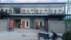 A two-story building with a balcony on the upper floor. - LEMBUNAI HOME STAY (Labuan Bajo)